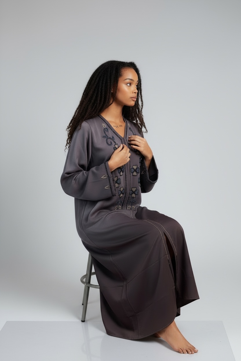 Model wearing charcoal embroidered abaya with floral detailing and wide sleeves