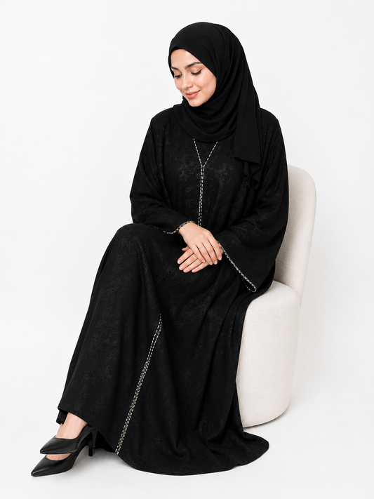 Seated view of the Midnight Noir Embroidered Closed Abaya showcasing flowing luxury black modest fashion by Simply Zida