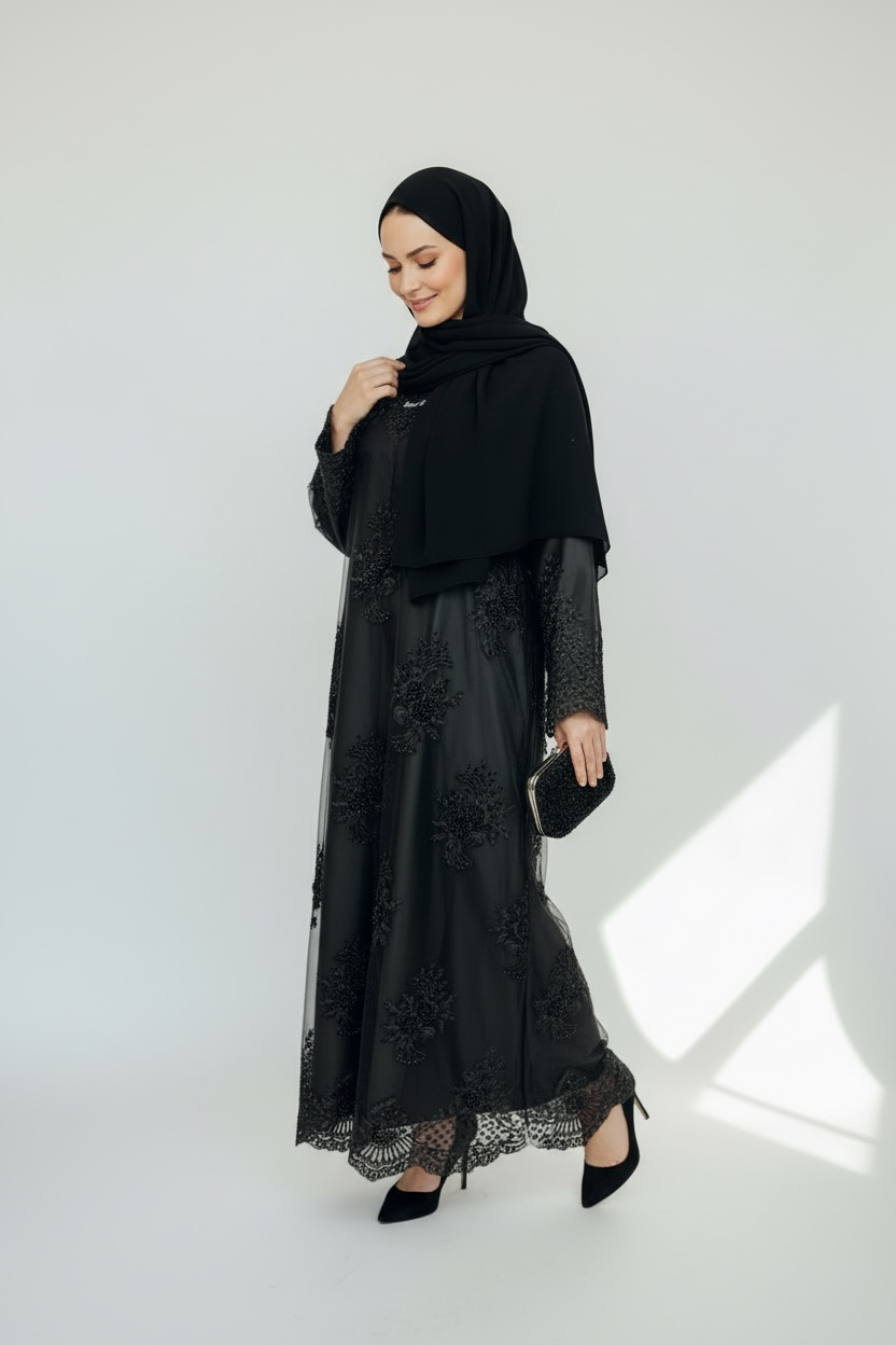 Side view of black lace abaya with scalloped hem and rhinestone detailing