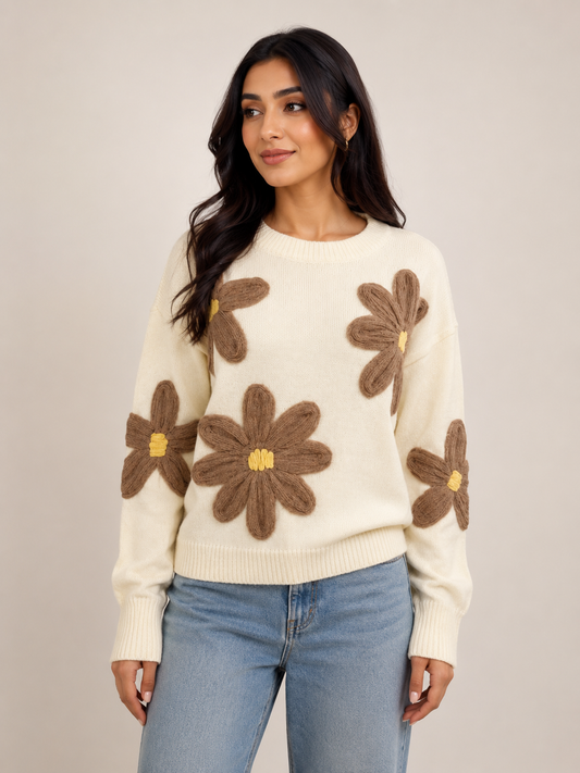 Female model wearing the Simply Zida Butterfly Bloom Knit Sweater in cream with oversized brown 3D floral appliqué details, paired with light blue jeans on a neutral studio background.