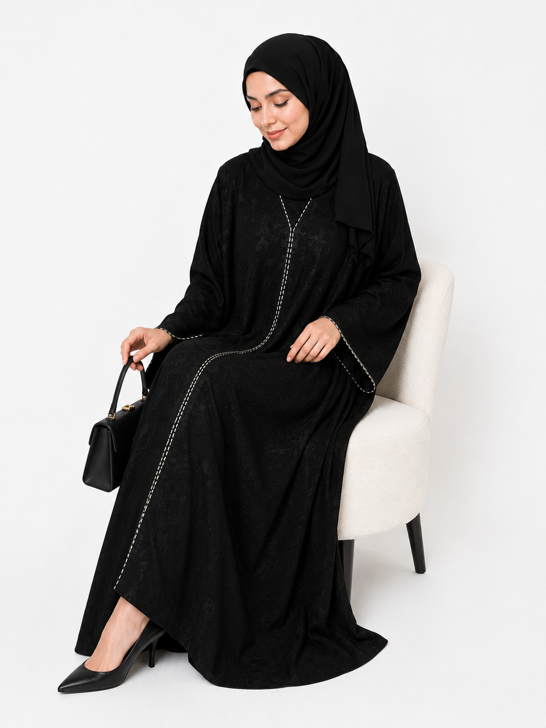 Luxury black embroidered closed abaya styled with a handbag in an elegant lifestyle setting by Simply Zida