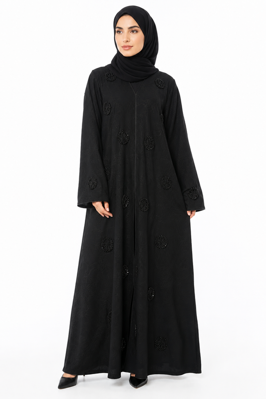 Model wearing the Noir Stone Closed Abaya in Black featuring elegant floral stone embellishments and a flowing modest silhouette by Simply Zida.
