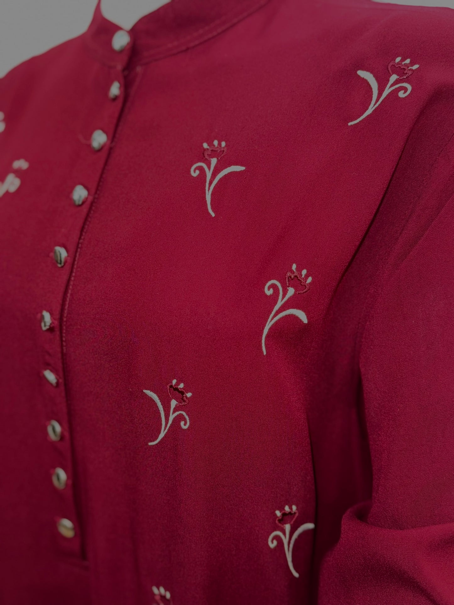 Close up of burgundy modest dress with subtle embroidery
